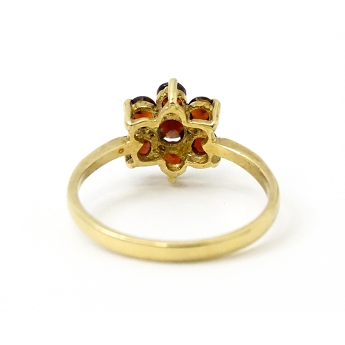 753 - A 9ct gold ring set with garnets in a floral setting. Ring size approx. O