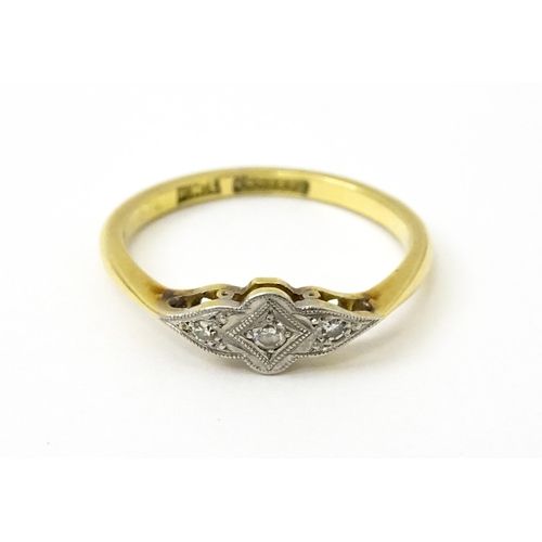 754 - An 18ct gold ring with three platinum set diamonds in an Art Deco style setting. Ring size approx. N... 