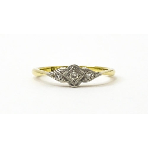 754 - An 18ct gold ring with three platinum set diamonds in an Art Deco style setting. Ring size approx. N... 