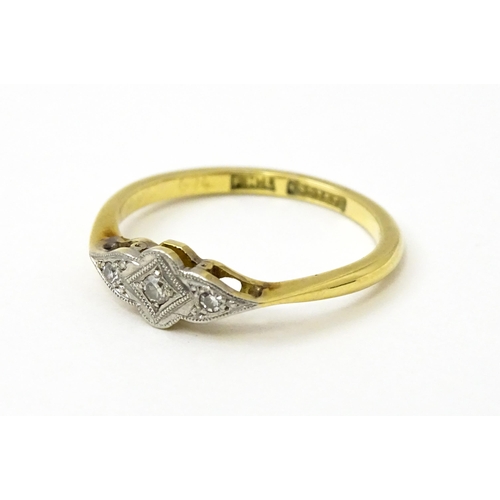 754 - An 18ct gold ring with three platinum set diamonds in an Art Deco style setting. Ring size approx. N... 