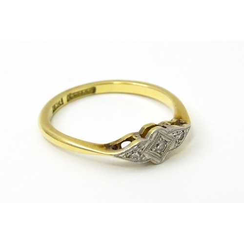 754 - An 18ct gold ring with three platinum set diamonds in an Art Deco style setting. Ring size approx. N... 