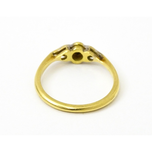 754 - An 18ct gold ring with three platinum set diamonds in an Art Deco style setting. Ring size approx. N... 