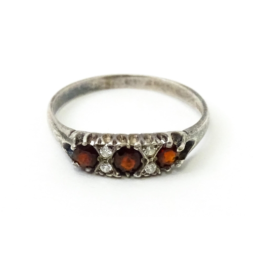 758 - A silver ring set with red and white stones. Ring size approx. T