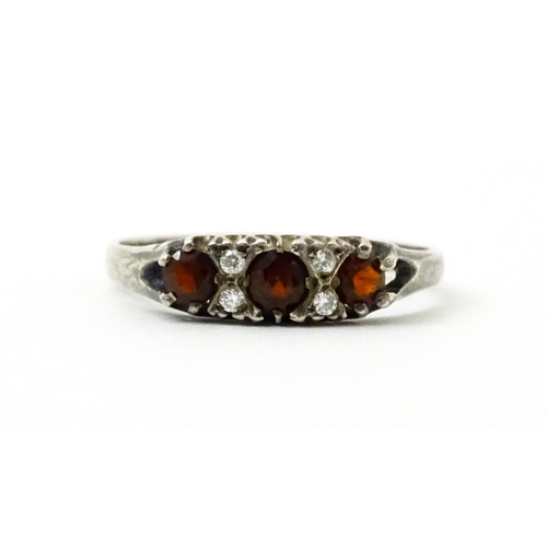 758 - A silver ring set with red and white stones. Ring size approx. T