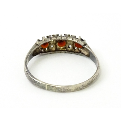 758 - A silver ring set with red and white stones. Ring size approx. T