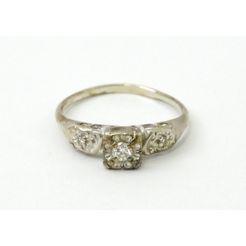 763 - A 14k white gold ring set with three illusion set diamonds. Ring size approx. M 1/2