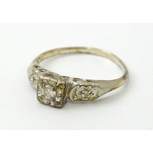 763 - A 14k white gold ring set with three illusion set diamonds. Ring size approx. M 1/2