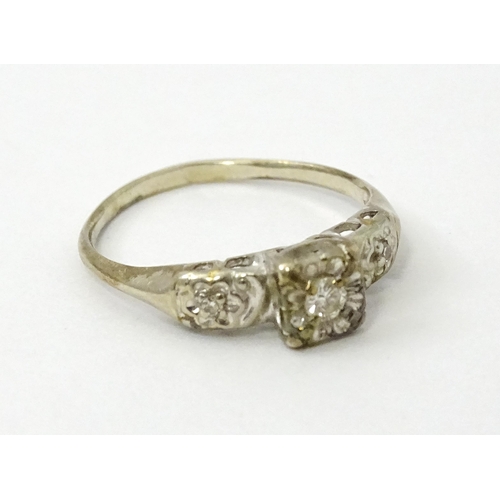 763 - A 14k white gold ring set with three illusion set diamonds. Ring size approx. M 1/2