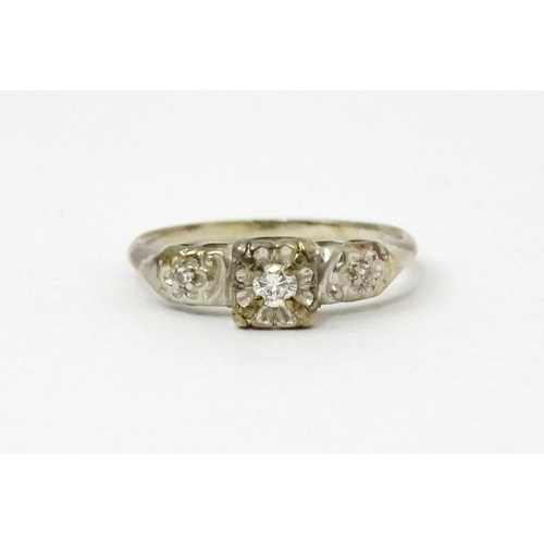 763 - A 14k white gold ring set with three illusion set diamonds. Ring size approx. M 1/2