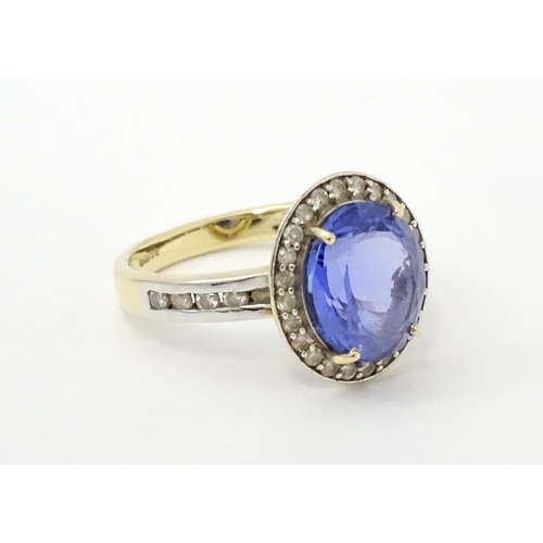 765 - A 9ct gold ring set with central tanzanite bordered by diamonds. Ring size approx. N 1/2