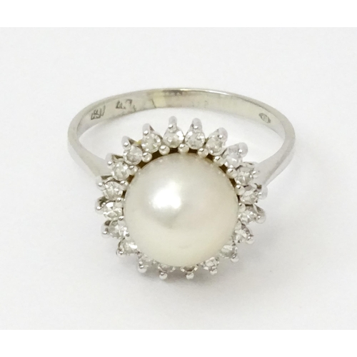 766 - An 18ct white gold ring set with central pearl bordered by diamonds. Ring size approx. P 1/2