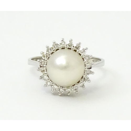 766 - An 18ct white gold ring set with central pearl bordered by diamonds. Ring size approx. P 1/2