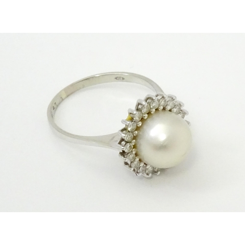 766 - An 18ct white gold ring set with central pearl bordered by diamonds. Ring size approx. P 1/2