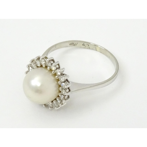 766 - An 18ct white gold ring set with central pearl bordered by diamonds. Ring size approx. P 1/2