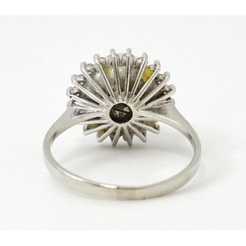 766 - An 18ct white gold ring set with central pearl bordered by diamonds. Ring size approx. P 1/2