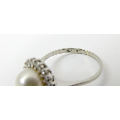 766 - An 18ct white gold ring set with central pearl bordered by diamonds. Ring size approx. P 1/2