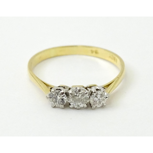 772 - An 18ct gold ring set with a trio of diamonds. Ring size approx. P