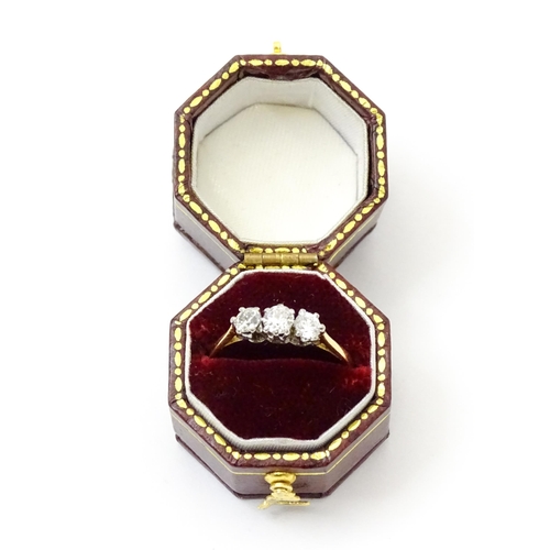 772 - An 18ct gold ring set with a trio of diamonds. Ring size approx. P