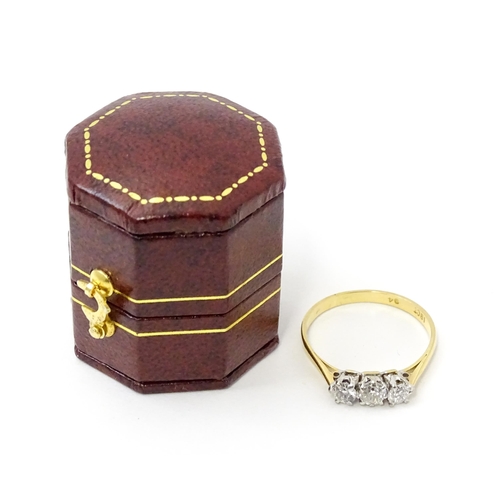 772 - An 18ct gold ring set with a trio of diamonds. Ring size approx. P