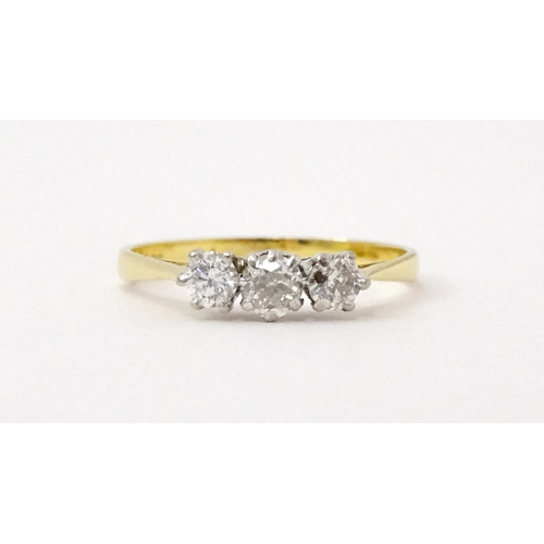 772 - An 18ct gold ring set with a trio of diamonds. Ring size approx. P