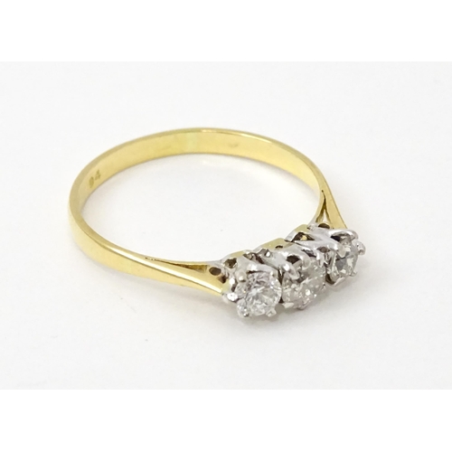 772 - An 18ct gold ring set with a trio of diamonds. Ring size approx. P