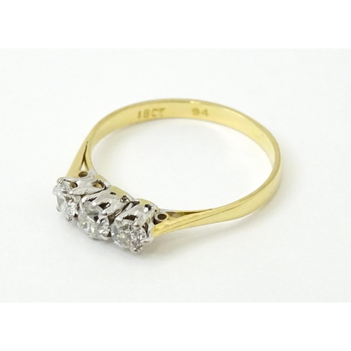 772 - An 18ct gold ring set with a trio of diamonds. Ring size approx. P