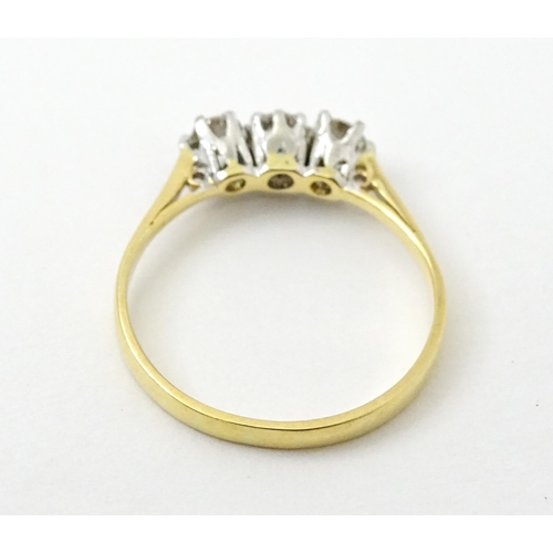 772 - An 18ct gold ring set with a trio of diamonds. Ring size approx. P