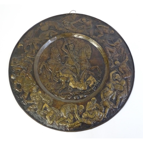 1507 - A large 20thC brass charger with relief decoration depicting Roman soldiers in battle, possibly depi... 