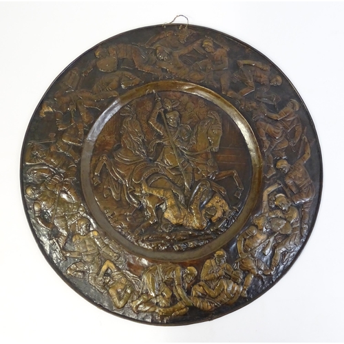 1507 - A large 20thC brass charger with relief decoration depicting Roman soldiers in battle, possibly depi... 