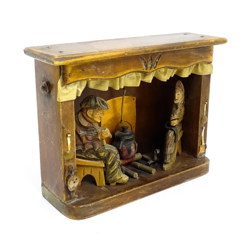 1509 - An early 20thC Continental folk art diorama depicting a naive carved interior scene with man and wom... 