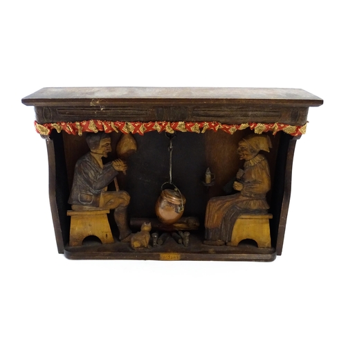 1510 - An early 20thC Continental folk art diorama depicting a naive carved interior scene with man and wom... 