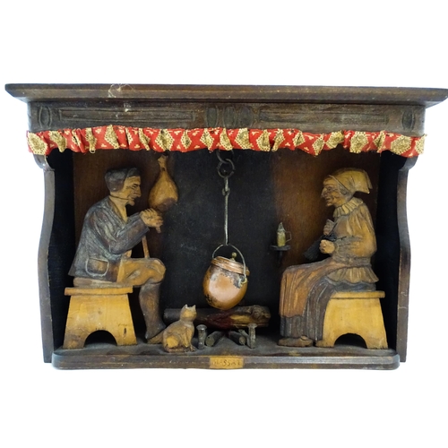 1510 - An early 20thC Continental folk art diorama depicting a naive carved interior scene with man and wom... 