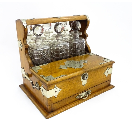 1532 - A Victorian oak tantalus / games compendium with silver plate mounts. With three glass decanters and... 