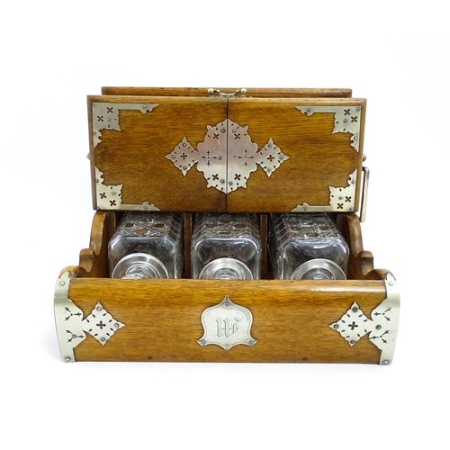 1532 - A Victorian oak tantalus / games compendium with silver plate mounts. With three glass decanters and... 