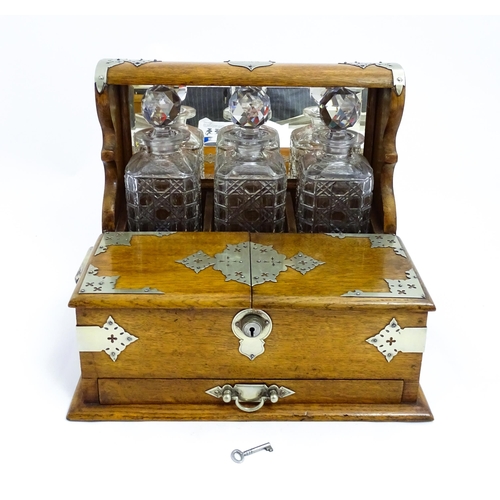 1532 - A Victorian oak tantalus / games compendium with silver plate mounts. With three glass decanters and... 