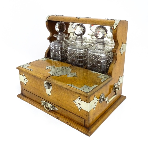 1532 - A Victorian oak tantalus / games compendium with silver plate mounts. With three glass decanters and... 