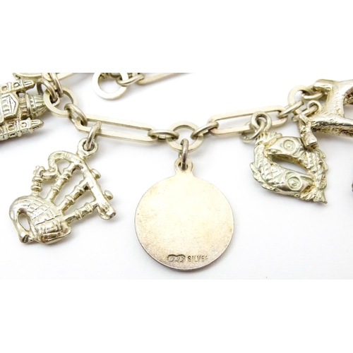 962 - A silver and white metal charm bracelet set with various silver and white metal charms to include a ... 