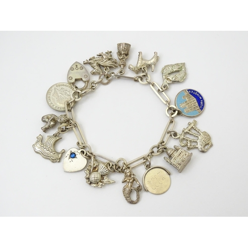 962 - A silver and white metal charm bracelet set with various silver and white metal charms to include a ... 