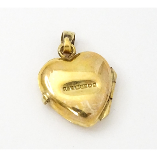 971 - A 9ct gold locket of heart form. Together with a pair of 9ct drop earrings, and an associated pendan... 