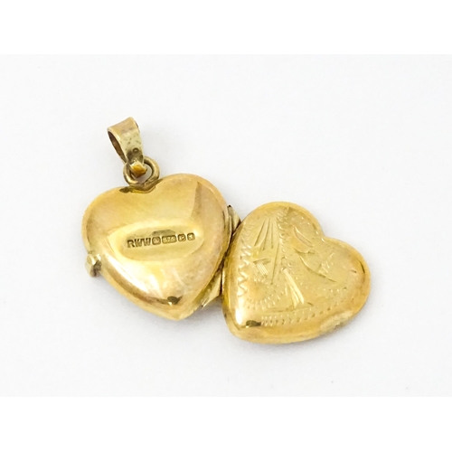 971 - A 9ct gold locket of heart form. Together with a pair of 9ct drop earrings, and an associated pendan... 