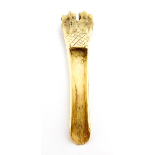 1465 - A 19thC carved knuckle bone apple corer with crosshatched decoration. Together with a treen pot and ... 