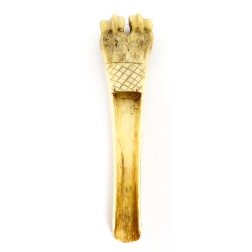 1465 - A 19thC carved knuckle bone apple corer with crosshatched decoration. Together with a treen pot and ... 