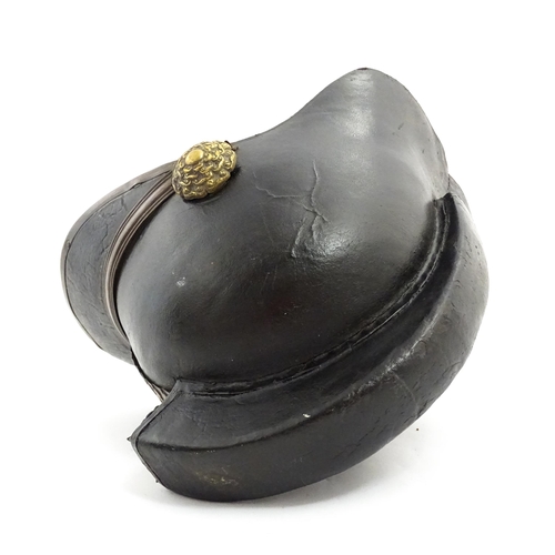 1469 - A 19thC fireman's helmet, the black leather shell with visor and rear brim, decorated with cockades,... 