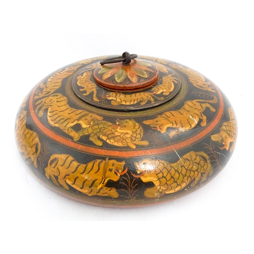 1540 - An Asian wooden box / container of circular form with lacquered and hand painted decoration depictin... 