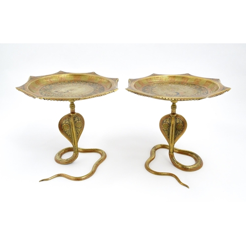 1548 - A pair of Benares brass tazzas with cobra / snake supports, the tops with stylised peacock detail an... 