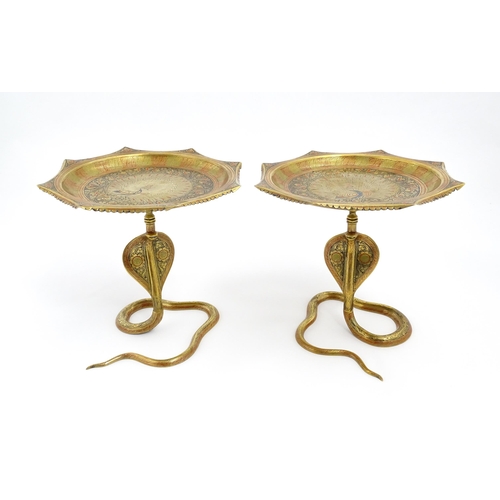 1548 - A pair of Benares brass tazzas with cobra / snake supports, the tops with stylised peacock detail an... 