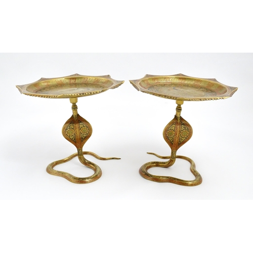 1548 - A pair of Benares brass tazzas with cobra / snake supports, the tops with stylised peacock detail an... 