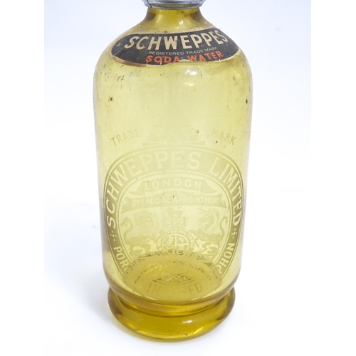 1552 - A mid 20thC amber glass soda siphon with etched Schweppes London emblem , together with an earlier b... 