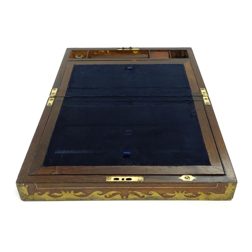 1553 - A Victorian writing slope with brass mounts, opening to reveal a fitted interior with two small conc... 