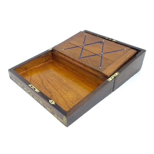 1553 - A Victorian writing slope with brass mounts, opening to reveal a fitted interior with two small conc... 